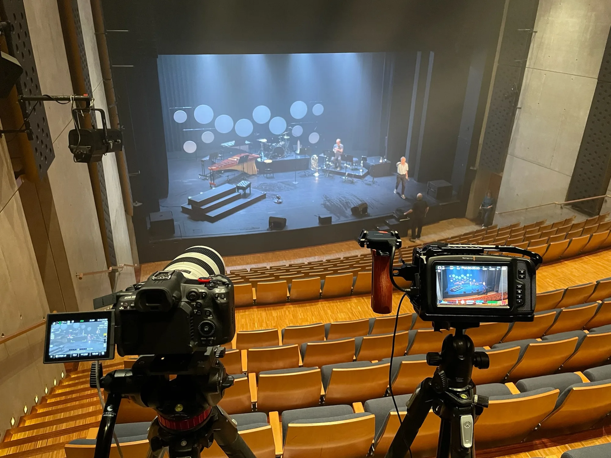 Cameras set up in a theatre for a video recording.